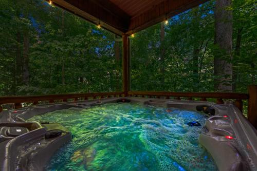 a hot tub in the middle of a forest at Dreamy Cabin & Outdoor Oasis! Mins to Nat'l Park! in Townsend