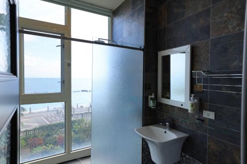 a bathroom with a sink and a glass shower door at View Ocean in Hualien City