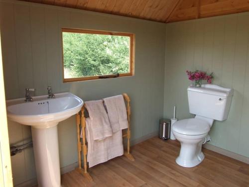 a bathroom with a sink and a toilet and a window at 'Oak' Yurt in West Sussex countryside in Fernhurst