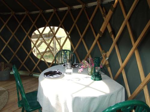 a table in a yurt with a white table cloth at 'Oak' Yurt in West Sussex countryside in Fernhurst