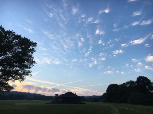 Un fienile in un campo sotto un cielo nuvoloso di 'Oak' Yurt in West Sussex countryside a Fernhurst