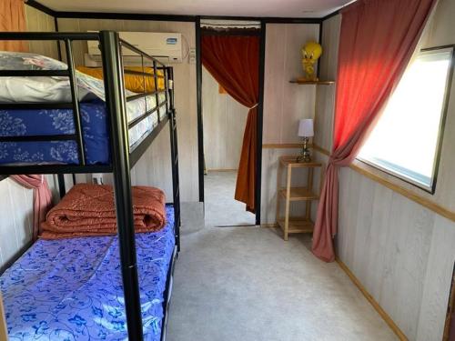 een kleine kamer met 2 stapelbedden en een raam bij Gîte pèlerin - "Les Sources" - Chambres Dortoirs in Le Vigan