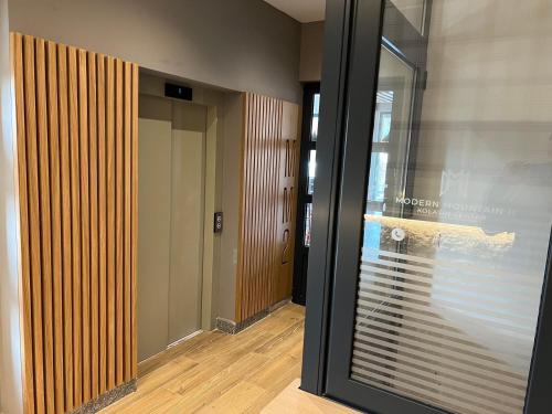 a hallway with a sliding glass door and a hallway with a hallway at Lavina MM2 in Kolašin
