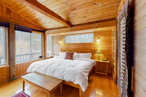 1 dormitorio en una cabaña de madera con 1 cama y 1 mesa en Newfane Hill Retreat, en Newfane