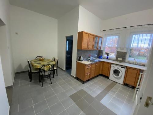 a kitchen with a table and a dining room at Tocc Apartman in Gyál
