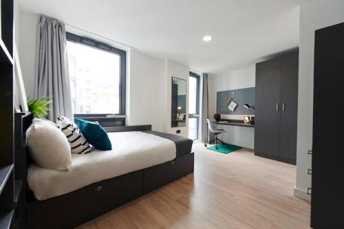 a bedroom with a bed and a large window at Chic Apartments and Private Bedrooms at Beckett House near Dublin City Centre in Dublin