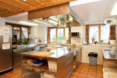 a large kitchen with a sink and a counter at Hotel Bahnhof in Zermatt