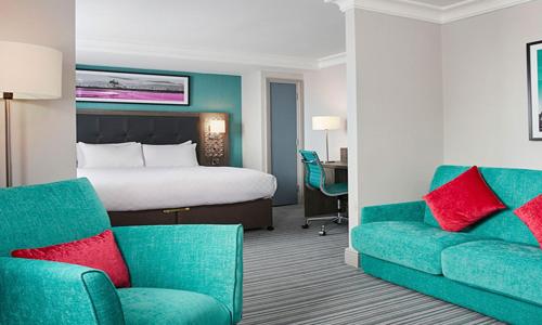 a hotel room with a bed and a couch at Leonardo Hotel Cheltenham in Cheltenham