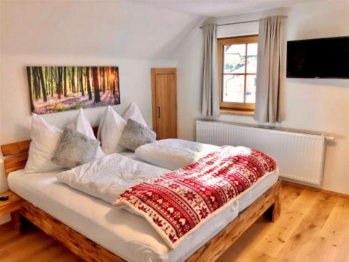a bedroom with a bed with a red blanket on it at Chalet Mama in Pruggern