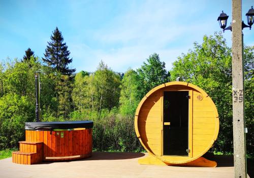 a wooden circle house with a trash can and a street light at Chata Kataryniarza in Karłów