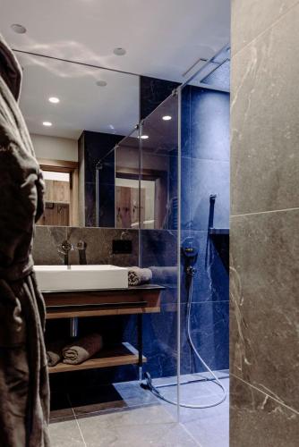 a bathroom with a glass shower with a sink and a tub at Biohof Ebengut in Maria Alm am Steinernen Meer