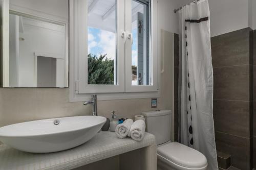 White Villa Milos في آداماس: حمام مع حوض ومرحاض ومرآة
