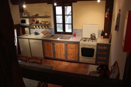 a kitchen with a sink and a stove at Gîtes de Peyrounou in Lacapelle-Biron