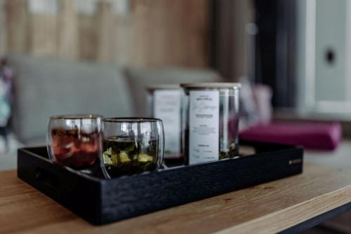 a black tray with two glasses of wine on a table at Biohof Ebengut in Maria Alm am Steinernen Meer