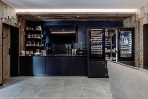 a kitchen with blue walls and a counter with a refrigerator at Biohof Ebengut in Maria Alm am Steinernen Meer