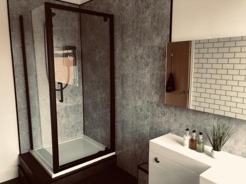 a bathroom with a shower and a sink at The Metropolitan Guest House in Whitley Bay