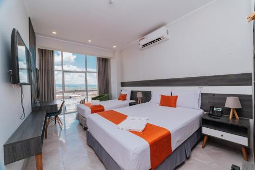 una camera d'albergo con due letti e una televisione di Palm Hotel Tarapoto a Tarapoto