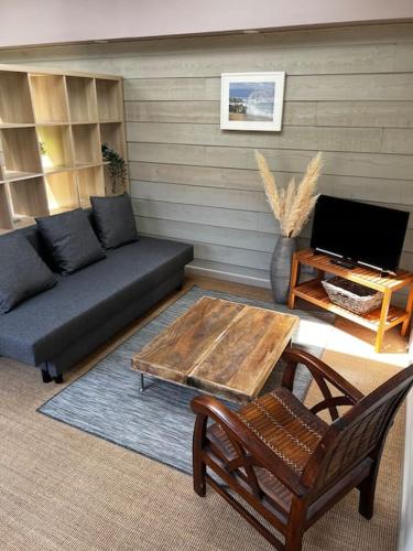 a living room with a couch and a coffee table at Maisonnette de charme aux portes d'Hossegor in Bénesse-Maremne