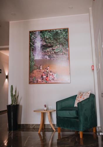a living room with a green couch and a painting on the wall at Palm Hotel Tarapoto in Tarapoto