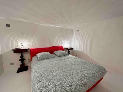 een slaapkamer met een bed met een rood hoofdeinde bij Jolie maison - Place des Lices à 350m in Saint-Tropez