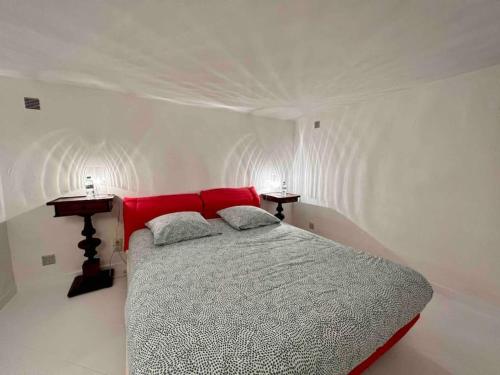 a bedroom with a bed with a red head board at Jolie maison - Place des Lices à 350m in Saint-Tropez