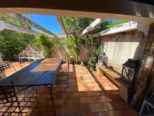un patio avec une table, des chaises et une cheminée dans l'établissement Jolie maison - Place des Lices à 350m, à Saint-Tropez