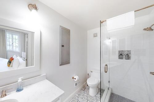 a white bathroom with a shower and a toilet at The Howe House in Nashville