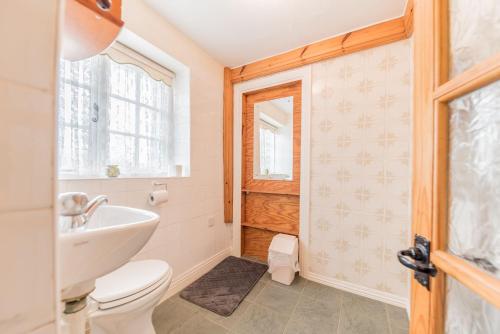 a bathroom with a toilet and a sink at Middlefield Cottage Coniston Water in Coniston