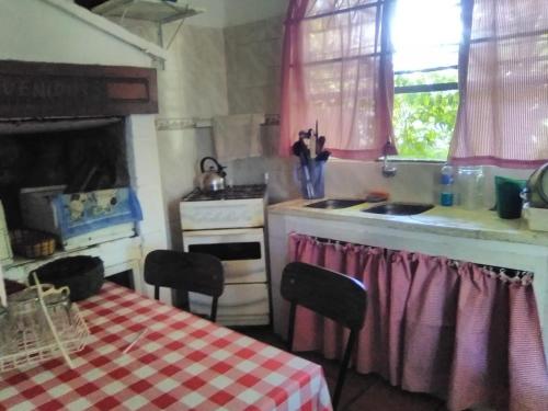 cocina con fogones, fregadero y mesa en Delastres, en Cuchilla Alta