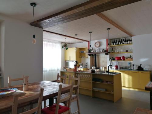 a kitchen with yellow cabinets and a wooden table at ALPINO B&B in Chiesa in Valmalenco
