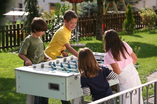 a group of young children playing with a giant foosball at Garni Appartements Almrausch in Burgusio