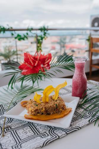 a plate of food on a table next to a vase at Palm Hotel Tarapoto in Tarapoto