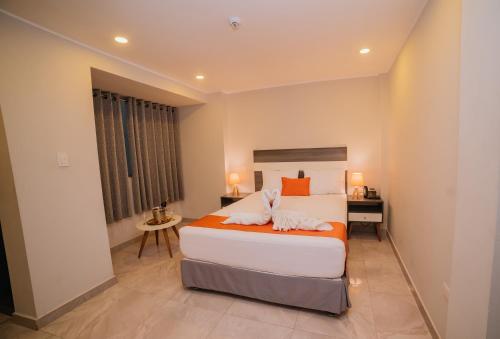 a bedroom with a large bed and a desk at Palm Hotel Tarapoto in Tarapoto