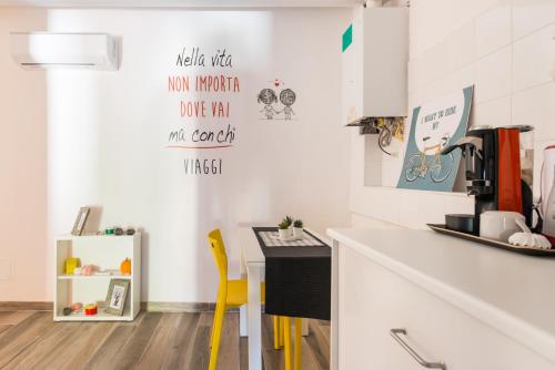 a kitchen with a counter and a yellow chair at Centrale APT con terrazza a 5min dal Pitti! - HomeUnity in Florence