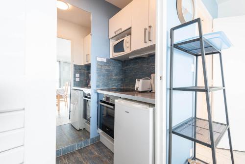 a kitchen with white cabinets and a ladder at Résidence Le Crystal Dinard Plage in Dinard