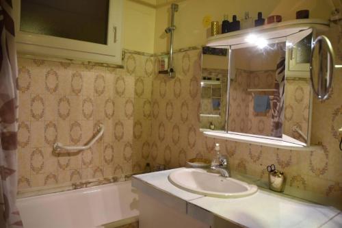 y baño con lavabo, espejo y bañera. en Residence Privée, en Niza