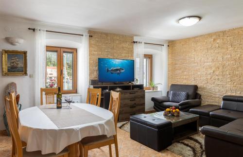 a living room with a table and a tv at Holiday Home By The Sea--Bougainvillea in Ston