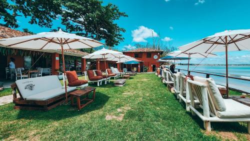 a row of chairs and umbrellas on the grass at Nativa Búzios in Búzios