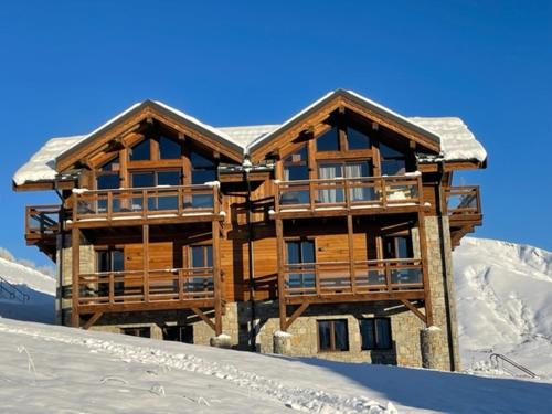 a large wooden house with snow on the roof at Magnifique chalet sur les pistes, le Paradis c'est ici ! in La Toussuire