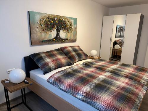 ein Schlafzimmer mit einem Bett und einem Baumgemälde in der Unterkunft Ferienwohnung Fischerweg in Bodensdorf
