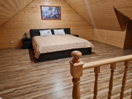 - une chambre avec un lit dans une cabane en bois dans l'établissement Apartamentai Renata, à Druskininkai