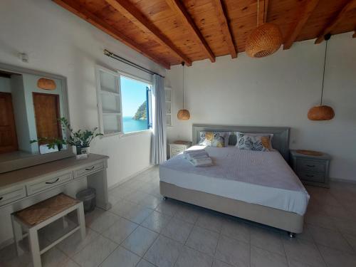 a bedroom with a bed and a large window at Hotel Agia Roumeli by the SEA in Agia Roumeli