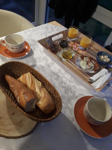 einen Tisch mit einem Tablett Brot und zwei Tassen Kaffee in der Unterkunft Les écureuils bourguignons in Montchanin