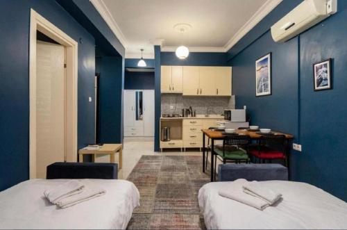 Habitación azul con 2 camas y cocina en Laluna Suite Apart Hotel, en Estambul