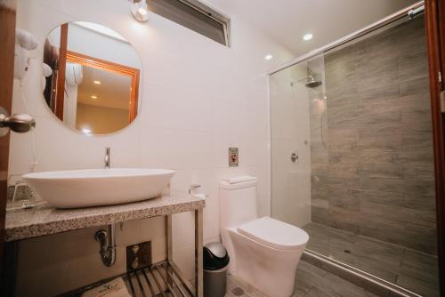 a bathroom with a sink and a toilet and a shower at Palm Hotel Tarapoto in Tarapoto