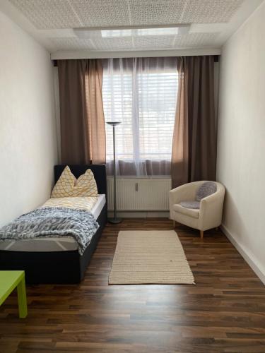 1 dormitorio con 1 cama, 1 silla y 1 ventana en Top-Apartment, en Mürzzuschlag
