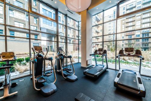 a gym with cardio machines in a building with windows at Qbik Loft Aparts in Warsaw