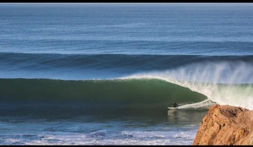 a person riding a wave on a surfboard in the ocean at Dar diafa samira in Mirleft