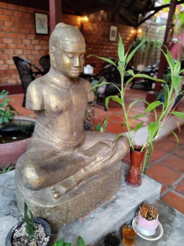 a statue of a man sitting in a tub at Soben Cafe Guesthouse & Restaurant in Siem Reap