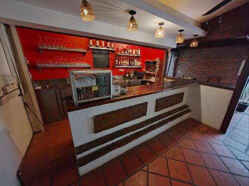 a bar in a restaurant with a red wall at Soben Cafe Guesthouse & Restaurant in Siem Reap